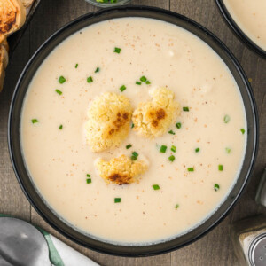 bowl of roasted cauliflower soup with pieces of roasted cauliflower on top.