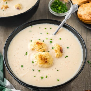 roasted cauliflower soup in black bowl.