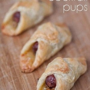 mini hot dogs wrapped in puff pastry on wood cutting board