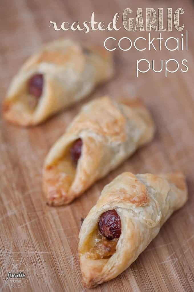 mini hot dogs wrapped in puff pastry on wood cutting board