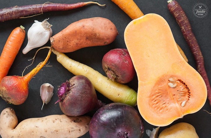 raw veggies on a black cutting board