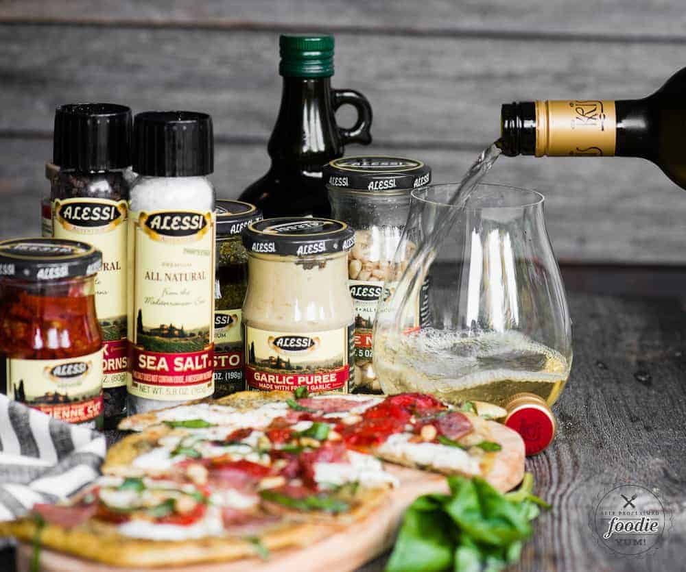 pouring a glass of pinot grigio wine with a flatbread pizza