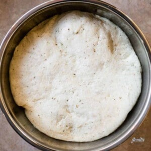 garlic herb flatbread dough that has risen in bowl