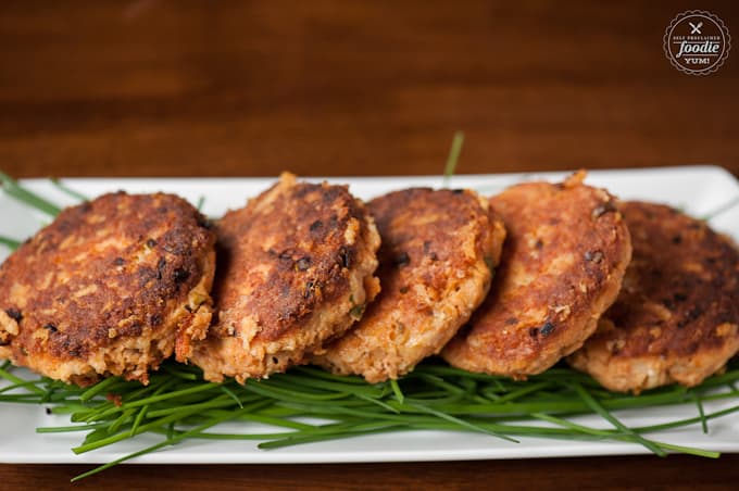 Salmon cakes on chives on platter