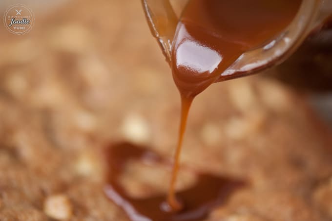 pouring caramel sauce onto cake