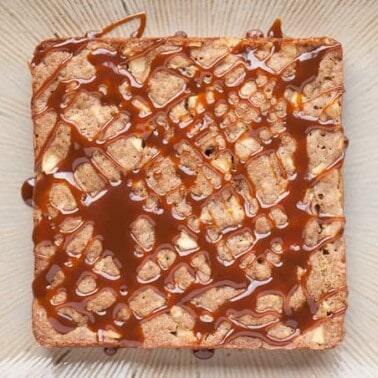 a square fresh apple cake drizzled with caramel sauce