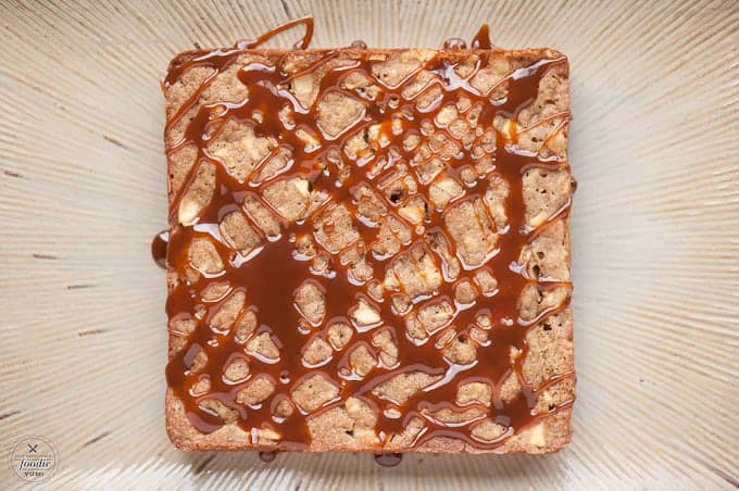 a square fresh apple cake drizzled with caramel sauce