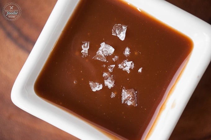 caramel sauce in square white dish with flakes of salt on top
