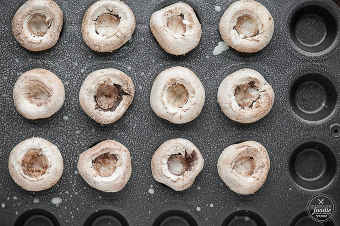 mushrooms with stem removed on mini muffin pan sprayed with cooking spray