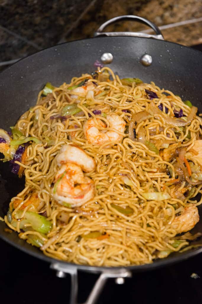 homemade shrimp chow mein in wok pan