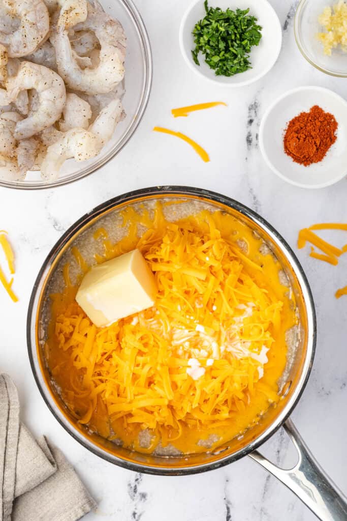 stirring butter and cheese into grits