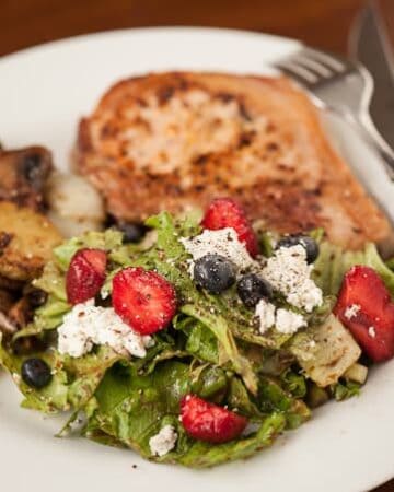 A delicious Simple Summer Salad with fresh greens, goat cheese, berries, and a homemade balsamic vinaigrette is the perfect side dish for lunch or dinner.