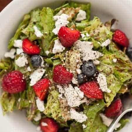 A delicious Simple Summer Salad with fresh greens, goat cheese, berries, and a homemade balsamic vinaigrette is the perfect side dish for lunch or dinner.