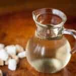 simple syrup in small glass pitcher with sugar cubes
