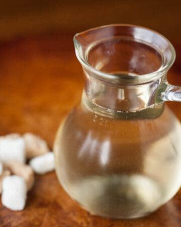 simple syrup in small glass pitcher with sugar cubes
