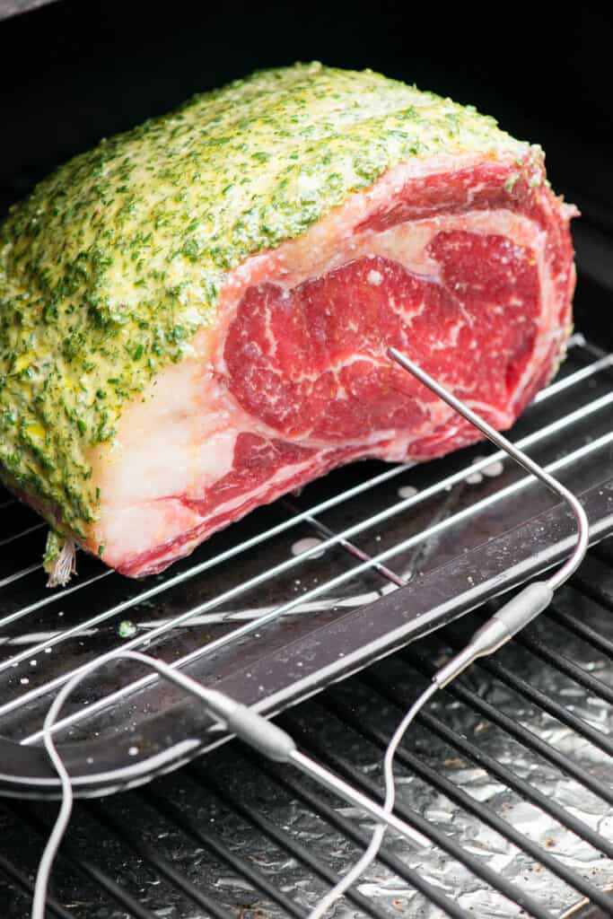 prime rib roast in smoker with thermometer