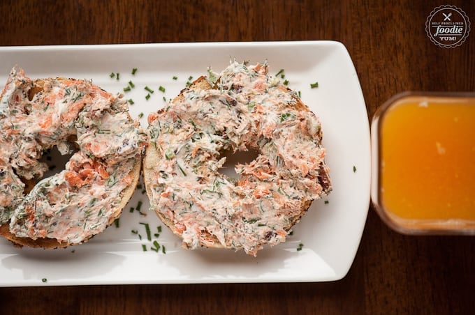 Smoked salmon spread on bagels with a glass of orange juice