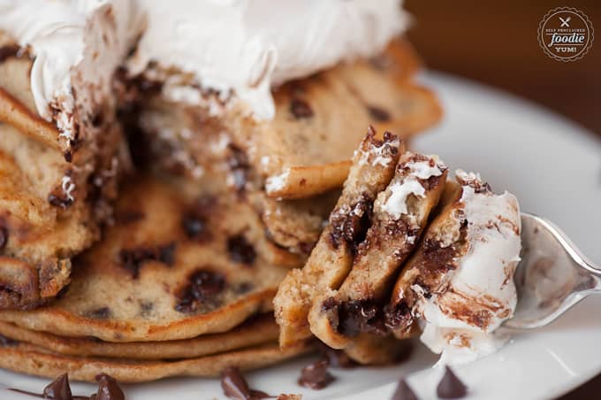 a bite of chocolate chip Graham cracker pancakes with marshmallow topping