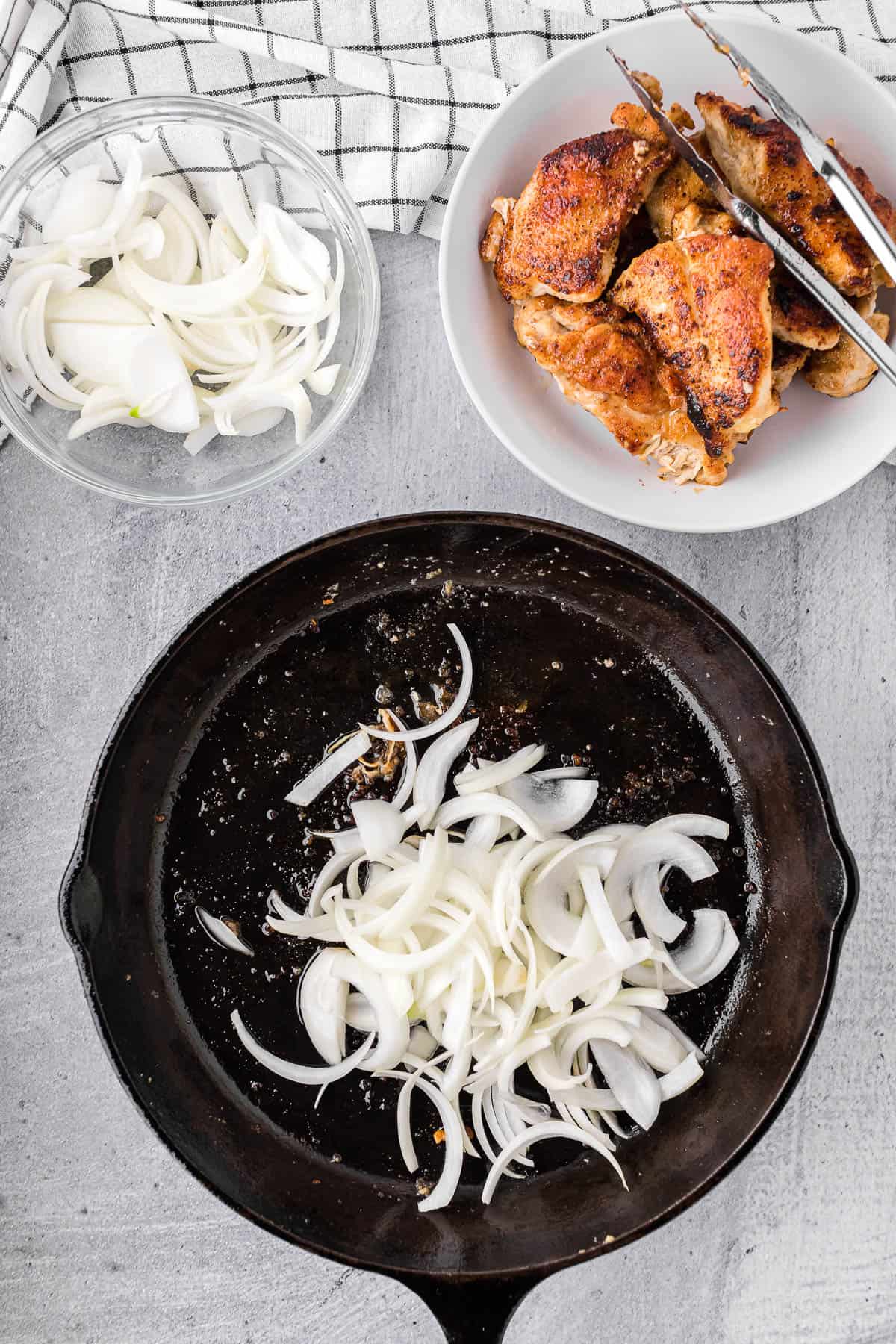 adding onions to hot cast iron skillet.