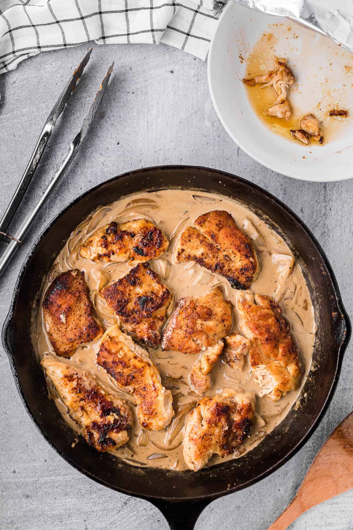 Adding cooked chicken back to skillet with onion gravy.