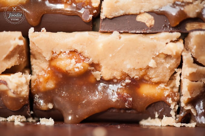 Close up picture of peanut butter fudge with caramel, peanuts and chocolate layers