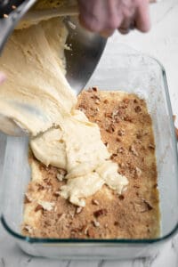 adding layer of cake batter to coffee cake.