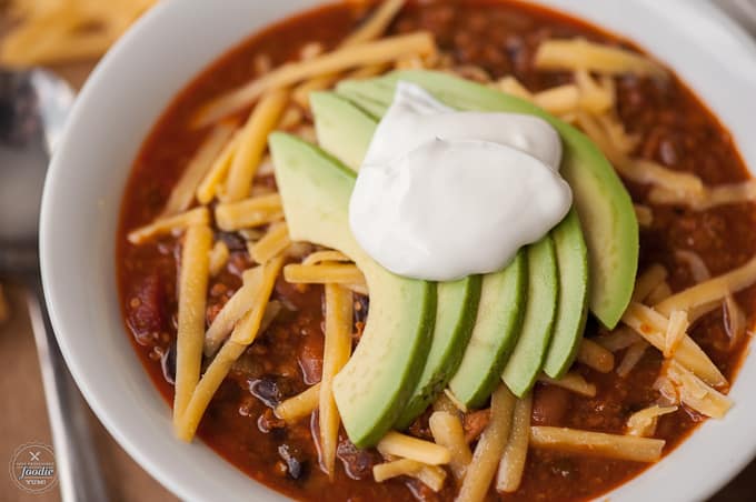 homemade chili topped with cheese and avocado