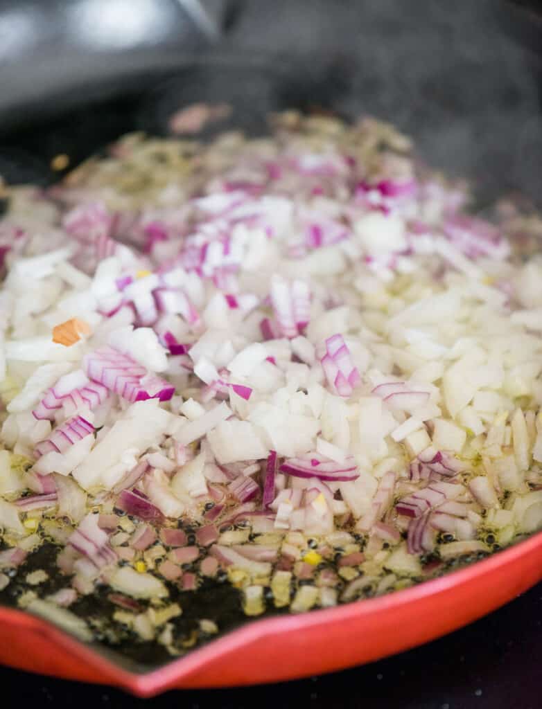 cooking diced red and yellow onions in pan
