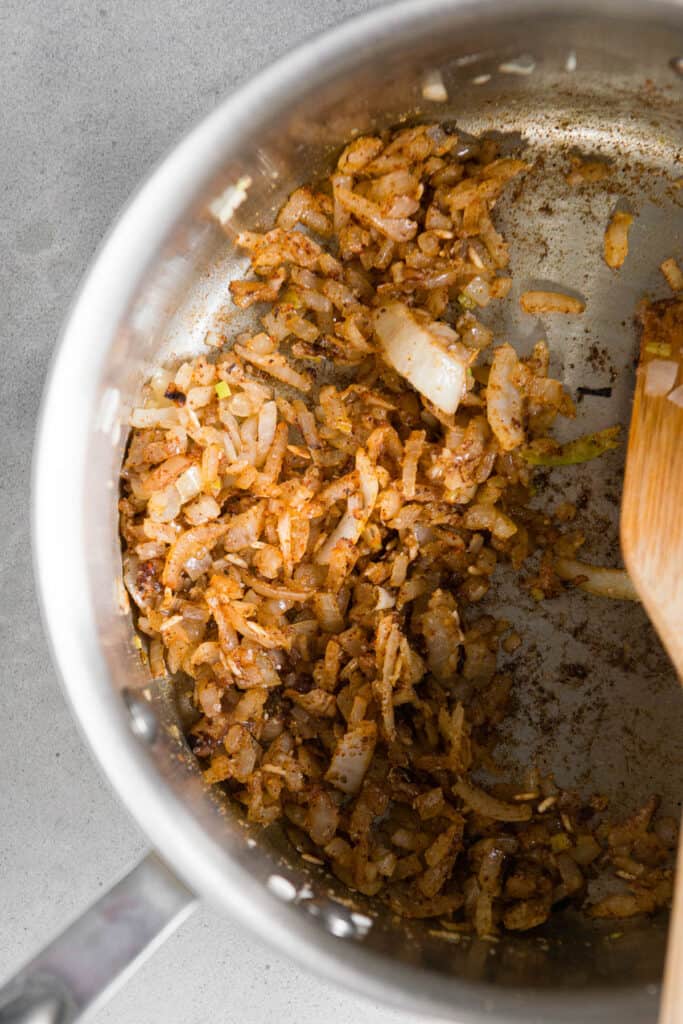 sauteed onions and spices in pan for Spanish rice recipe.