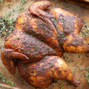 spatchcock smoked chicken with dry rub on baking sheet