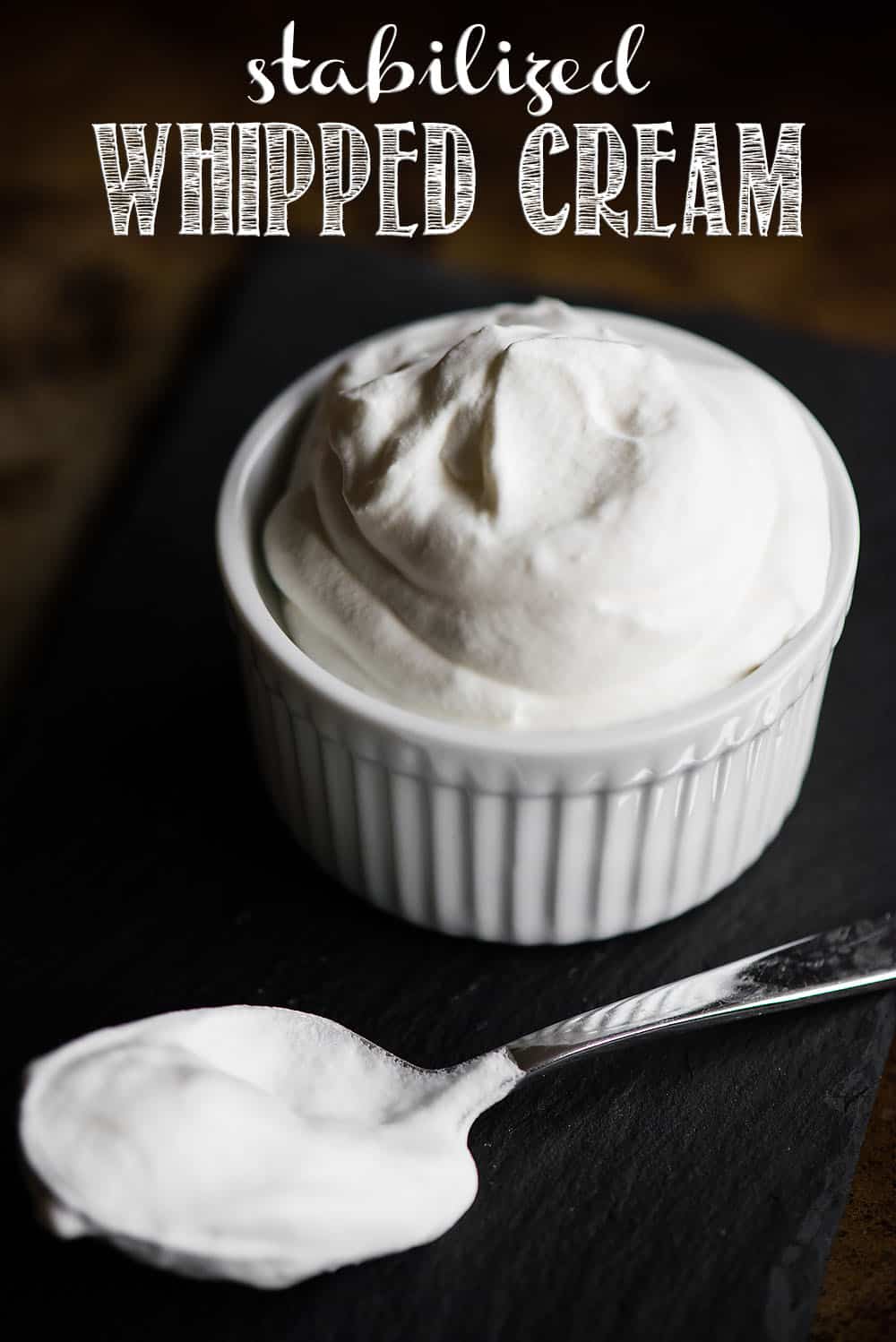 Stabilized Whipped Cream tastes just like sweet homemade whipped cream, except this version will hold it's shape with the addition of a secret ingredient. Never again will you want to buy a tub of that artificial whipped topping. This recipe is perfect for all kinds of desserts! #whippedcream #stabilizedwhippedcream #cream #realcream