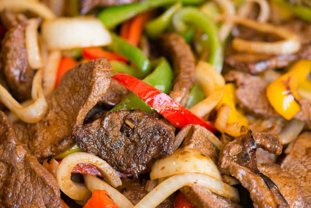 close up of steak with onions and peppers