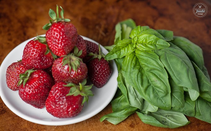 a plate of strawberries and basil