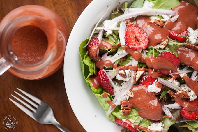 A plate of salad with strawberry basil vinaigrette