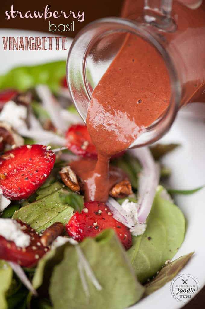 strawberry basil vinaigrette being poured on a salad