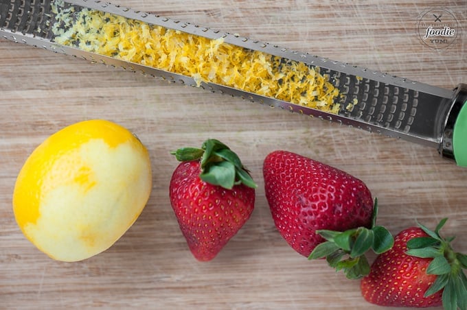lemon zest and fresh strawberries on cutting board