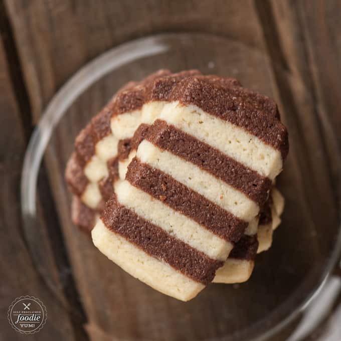 A close up of a striped chocolate cookie on top of a stack of cookies