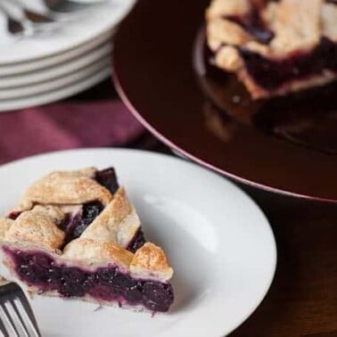 A piece of homemade berry pie on a white plate