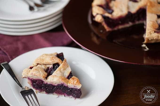 A piece of homemade berry pie on a white plate