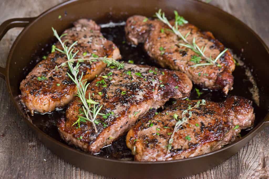 New York Strip Steaks in cast iron pan