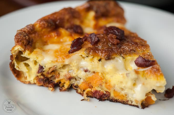 A close up of a slice of potato and bacon frittata