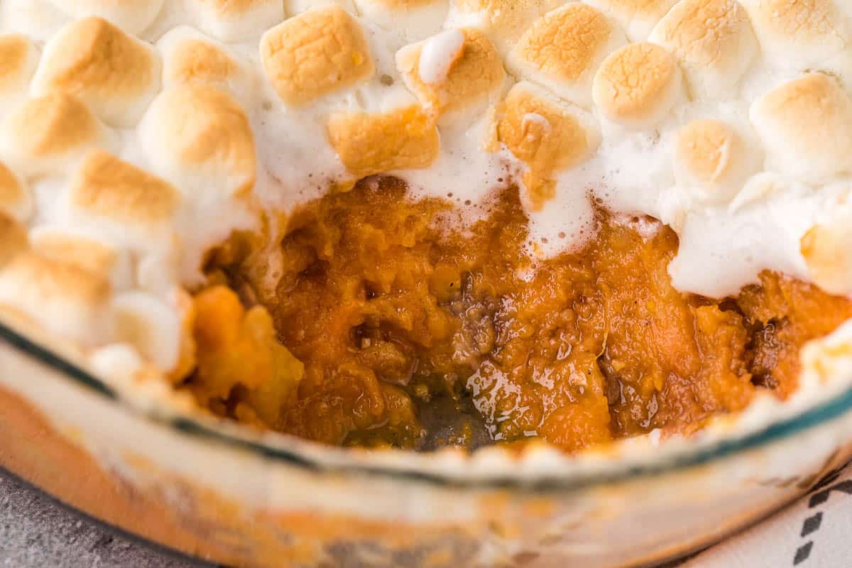 casserole dish of sweet potato casserole with scoop removed.
