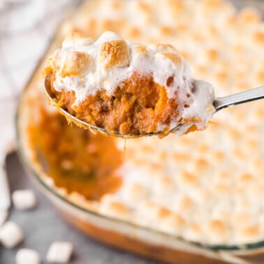 Scoop of homemade sweet potato casserole with marshmallows.
