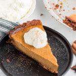 slice of homemade sweet potato pie with a gingersnap crust topped with whipped cream.