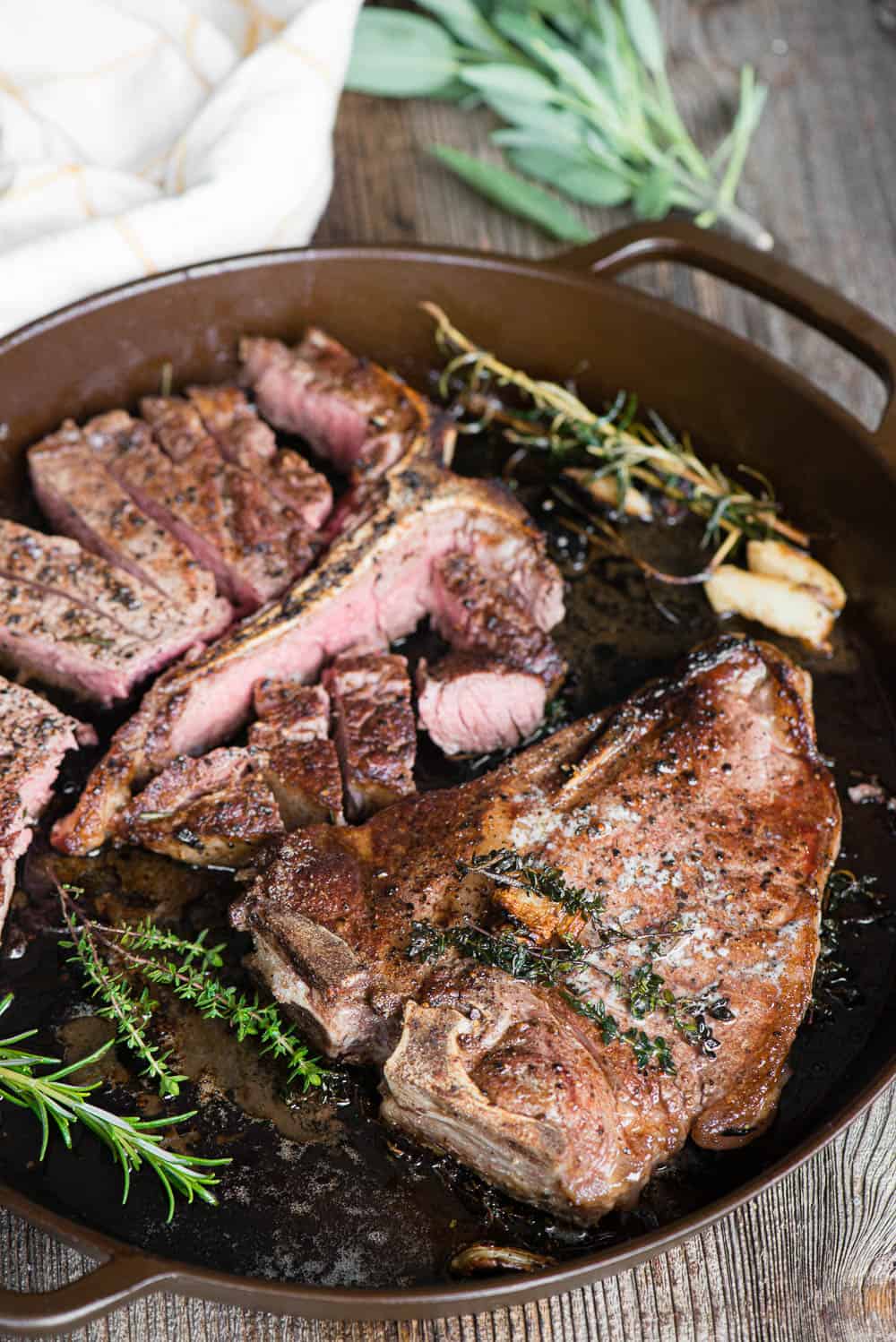 cast iron pan with two steaks