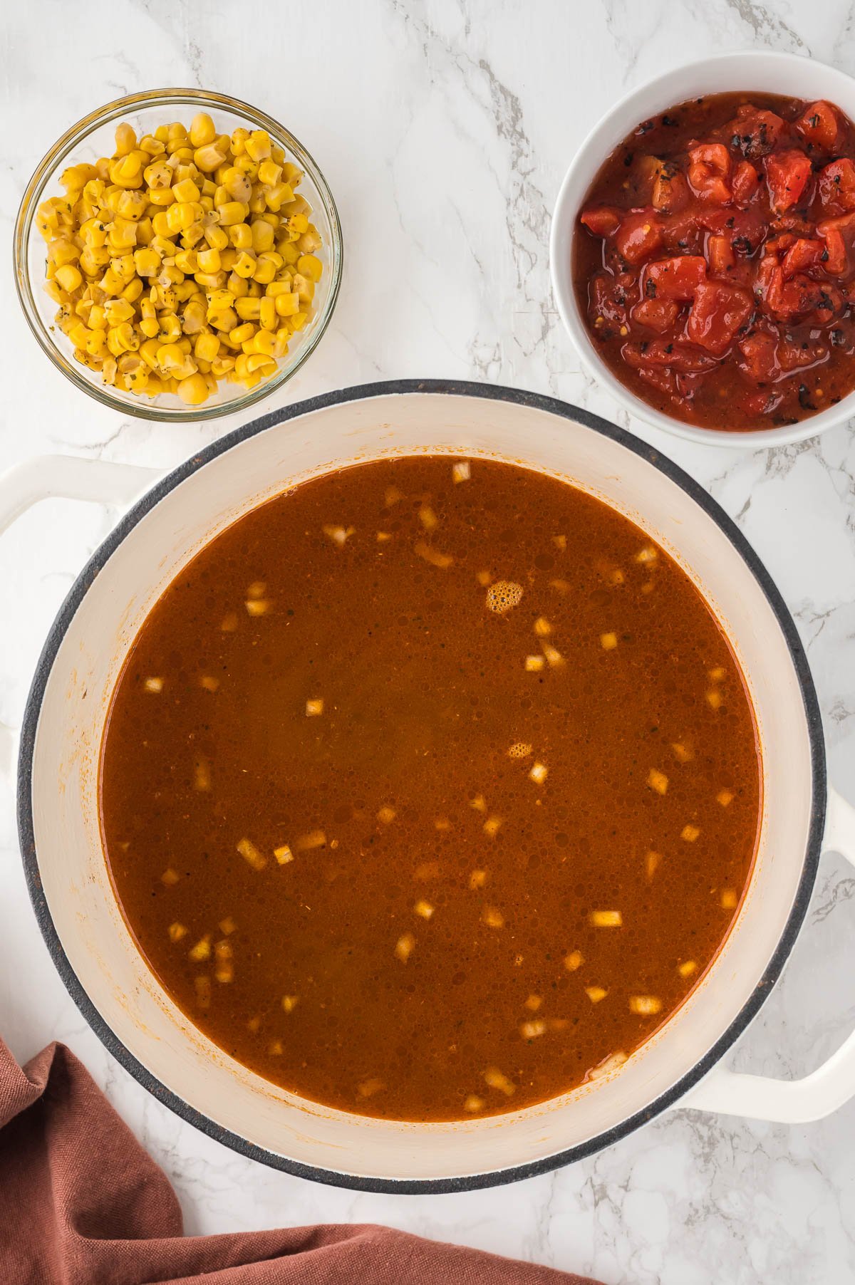 adding ingredients to pot to make taco soup recipe.