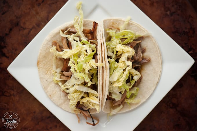 corn tortillas, meat, and lettuce on a plate