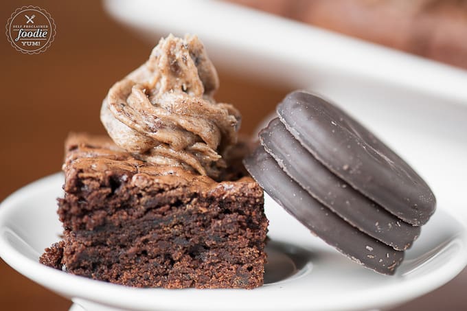 homemade frosted brownie next to three thin mint cookies