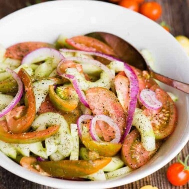 bowl of marinated tomato cucumber salad with heirloom tomatoes