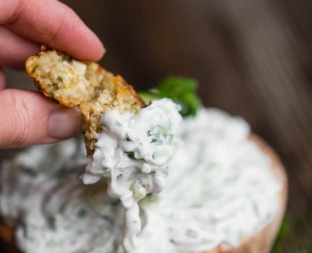 dipping falafel in Tzatziki sauce